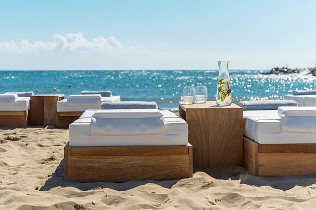 Ležadlá na pláži v Knossos Beach Bungalow & Suites