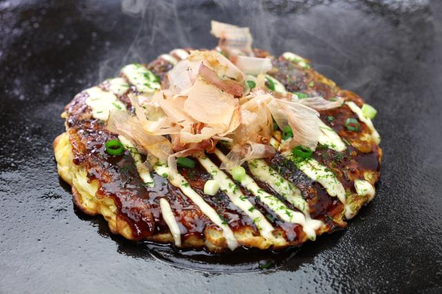 Okonomiyaki sa pripravuje z cesta, rôznych náplní a môže byť po