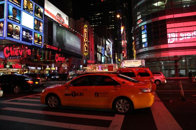 Ulice okolo Times Square sú plné svetelných reklám a ľudí. Toto
