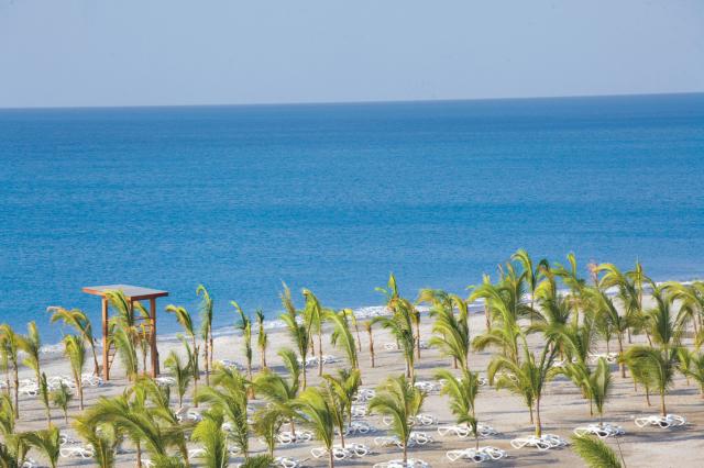 Strážená pláž v jemnom tieni paliem. Foto: Riu Playa Blanca