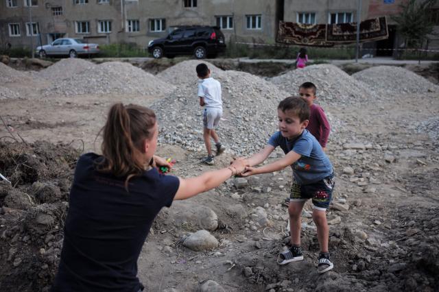 Sára rozdáva miestnym deťom žijúcim na sídlisku cukríky. foto: 