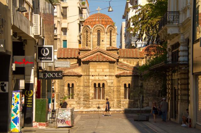 Uprostred ulice leží maličký kamenný grécky ortodoxný kostolík 
